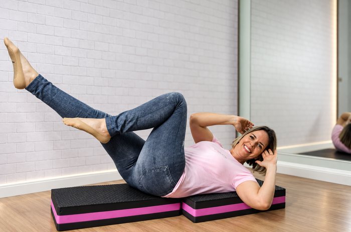 Ana Carla Reis realizando exercício abdominal de Pilates no solo
